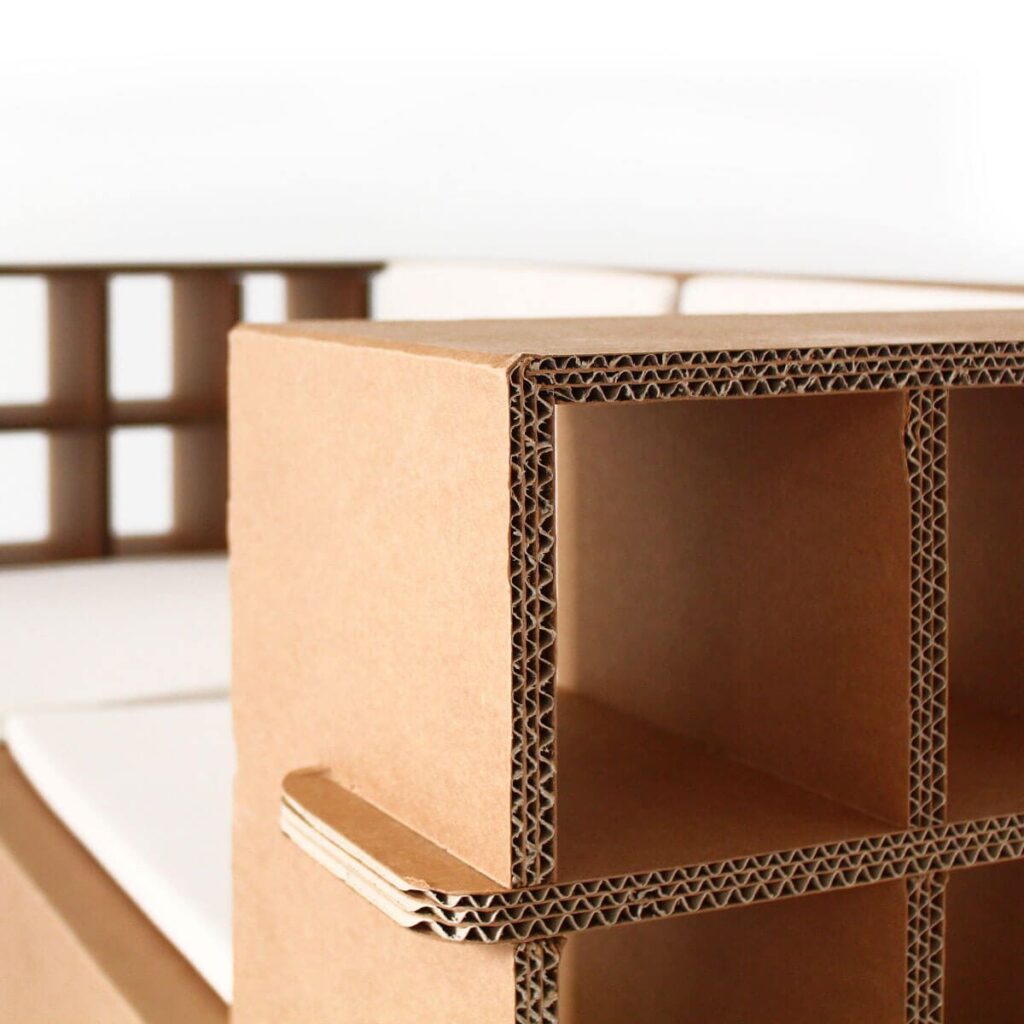 Détail d'un canapé en carton structuré par des panneaux épais et des angles renforcés, idéal pour les espaces modulables et écologiques comme les bureaux créatifs ou les salons d'accueil professionnels - Le Meuble en Carton une marque du groupe Natur Design