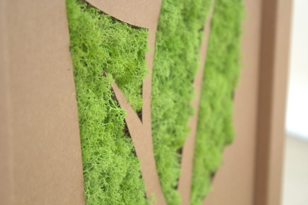 Détails d'un bureau en carton écologique avec panneaux verticaux en mousse végétale pour salle de pause ou espace professionnel, intégrant des éléments naturels et durables dans l'aménagement intérieur - Le Meuble en Carton une marque du groupe Natur Design