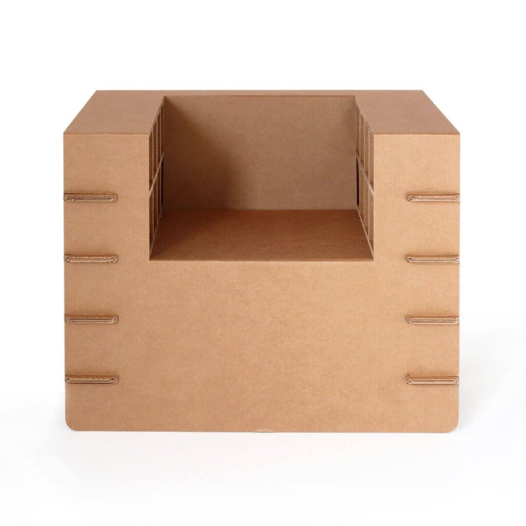 Fauteuil en carton écologique monté à l'état vide, avec charnières métalliques visibles pour les pieds et poignées, conçu pour l’aménagement des espaces professionnels ou des salles de pause dans les entreprises - Le Meuble en Carton une marque du groupe Natur Design