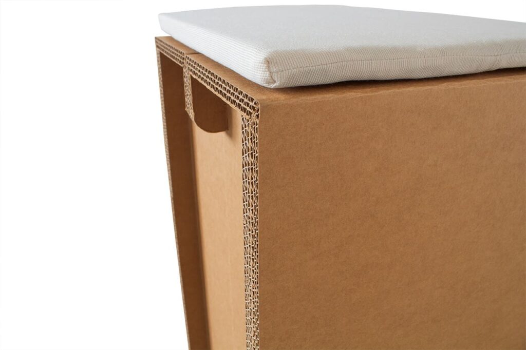 Tabouret en carton écologique pour stands événementiels, avec assise textile cousue et structure renforcée en panneaux cartonnés, idéal pour décoration scénographique professionnelle - Le Meuble en Carton une marque du groupe Natur Design