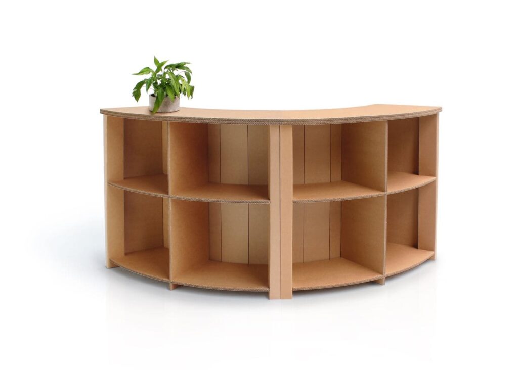 Banque d'accueil en carton modulable avec plateau central pour événements professionnels ou stands événementiels, intégrée dans l’aménagement de magasins et espaces scénographiques. Structure cartonnée avec compartiments organisés pour accueil client, idéalement adaptée aux espaces professionnels et durables en milieu pro - Le Meuble en Carton une marque du groupe Natur Design