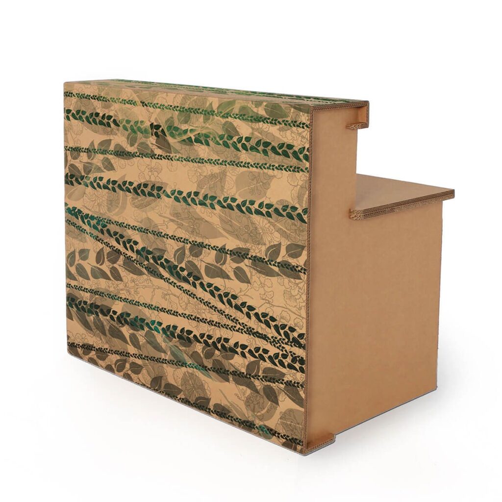 Banque d'accueil en carton décorée avec motifs végétaux pour l’aménagement de magasins et stands événementiels, idéale pour les salons professionnels et espaces scéniques - Le Meuble en Carton une marque du groupe Natur Design