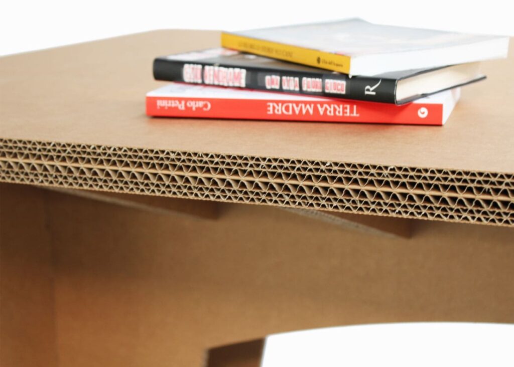 Bureau en carton écologique pour aménagement d'entreprise ou salle de pause, avec plateau cartonné visible et livres posés dessus, idéal pour espaces professionnels durables et modulables - Le Meuble en Carton une marque du groupe Natur Design