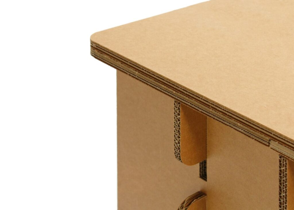 Détail d'un bureau en carton écologique pour aménagement d'entreprises, montrant une structure solide avec plateau haut et support de tiroir en carton recyclé, idéal pour les espaces bureautiques et salles de pause professionnels - Le Meuble en Carton une marque du groupe Natur Design