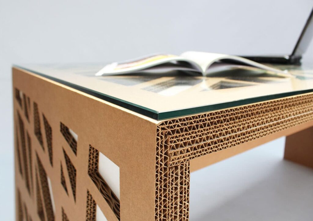 Bureau en carton écoresponsable avec plateau transparent, conçu pour les espaces professionnels et les bureaux d'entreprise. Structure en panneaux cartonnés renforcés aux pieds, idéale pour les salles de pause ou open space - Le Meuble en Carton une marque du groupe Natur Design