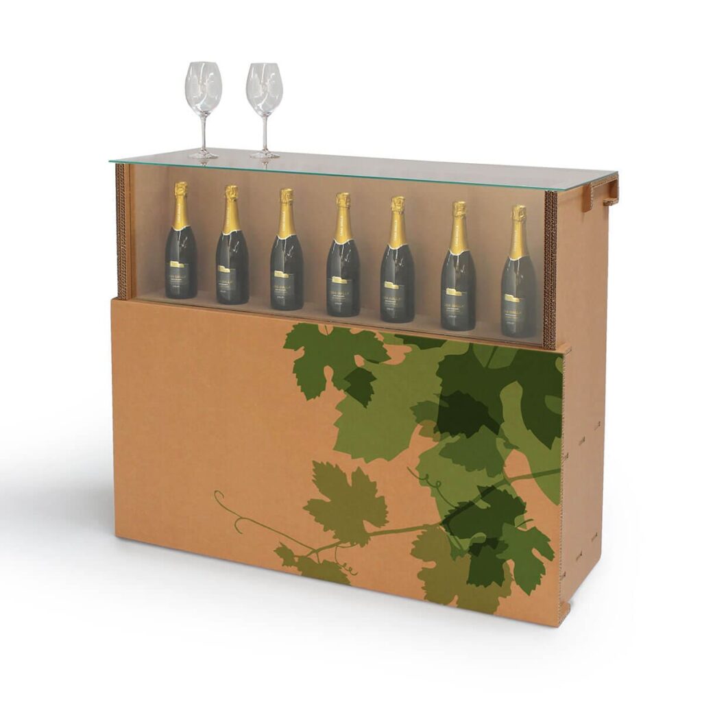 Comptoir en carton LOGAN E avec étagères de stockage pour bouteilles de champagne ou vin, décorées d'un motif végétal vert et métallique sur le panneau inférieur, idéal pour stands événementiels professionnels, salons ou espaces de réception - Le Meuble en Carton une marque du groupe Natur Design