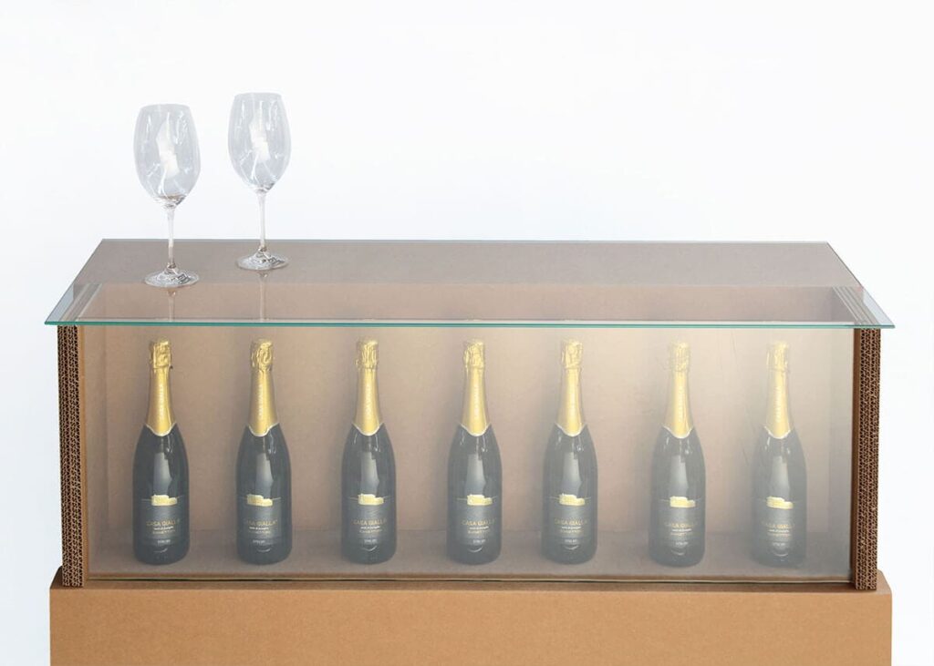 Comptoir en carton transparent avec plateau vitré pour exposition de bouteilles de champagne ou vins dans des événements professionnels et stands événementiels, idéal pour salons et aménagement de points de vente haut de gamme - Le Meuble en Carton une marque du groupe Natur Design