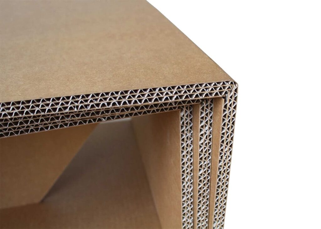Détail d'une table basse en carton écrins avec structure renforcée à motifs géométriques, idéale pour l'aménagement des entreprises et les espaces de pause professionnels - Le Meuble en Carton une marque du groupe Natur Design