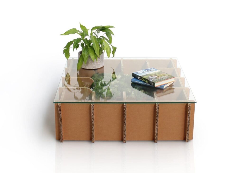 Table basse en carton écologique avec plateau transparent intégré, idéale pour les espaces professionnels ou salles de pause. Structure solide en panneaux cartonnés renforcés, combinée à une surface vitrée pour un usage pratique et esthétique dans l’aménagement d’entreprise - Le Meuble en Carton une marque du groupe Natur Design
