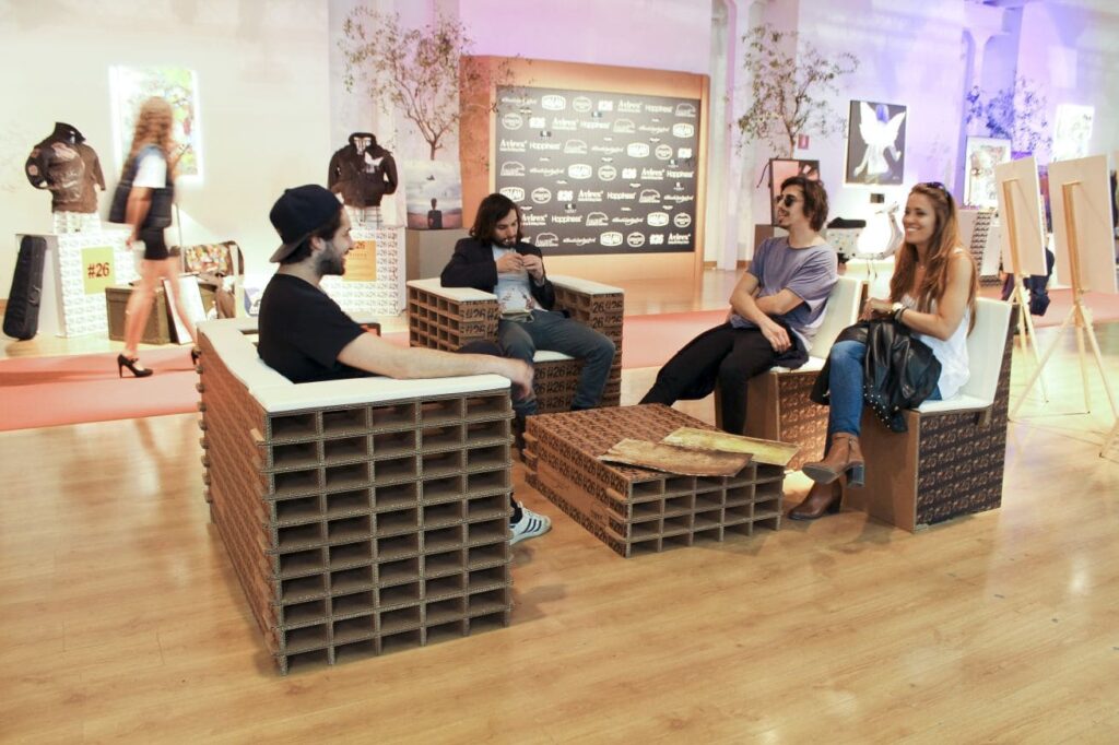 Table basse en carton Mont Blanc utilisée pour l'aménagement d'espaces professionnels comme les salles de pause ou événements, avec des sièges modulaires et des plateaux cartonnés visibles sur le plan de travail. Conçue pour les bureaux créatifs, stands événementiels et scénographie moderne - Le Meuble en Carton une marque du groupe Natur Design