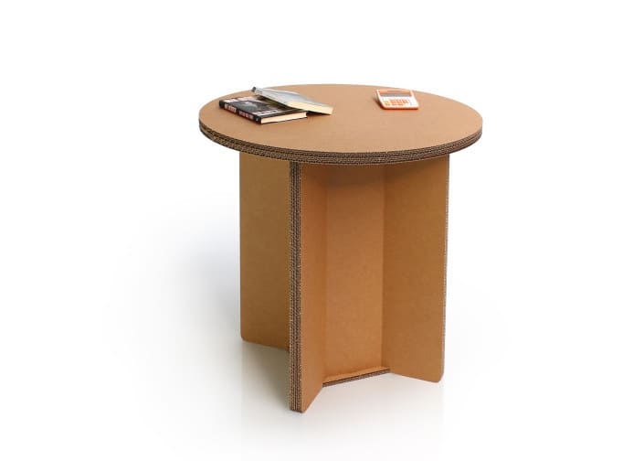 Table ronde en carton recyclé pour espaces professionnels et événements, plateau épais visible avec structure stable en panneaux cartonnés. Idéale pour les bureaux, salles de pause ou stands événementiels en scénographie moderne - Le Meuble en Carton une marque du groupe Natur Design