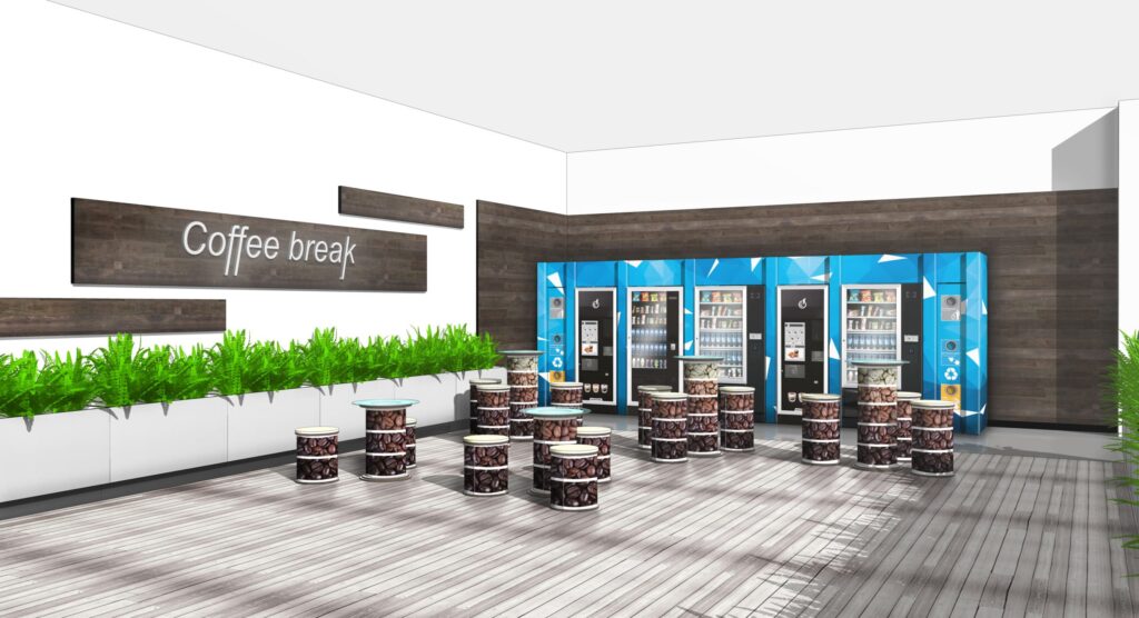 Table en carton ETNA pour espaces professionnels et événements, intégrée dans une zone café break avec des plateaux cartonnés empilés et décorés de motifs graphiques, idéale pour les bureaux, salles de pause et stands événementiels - Le Meuble en Carton une marque du groupe Natur Design