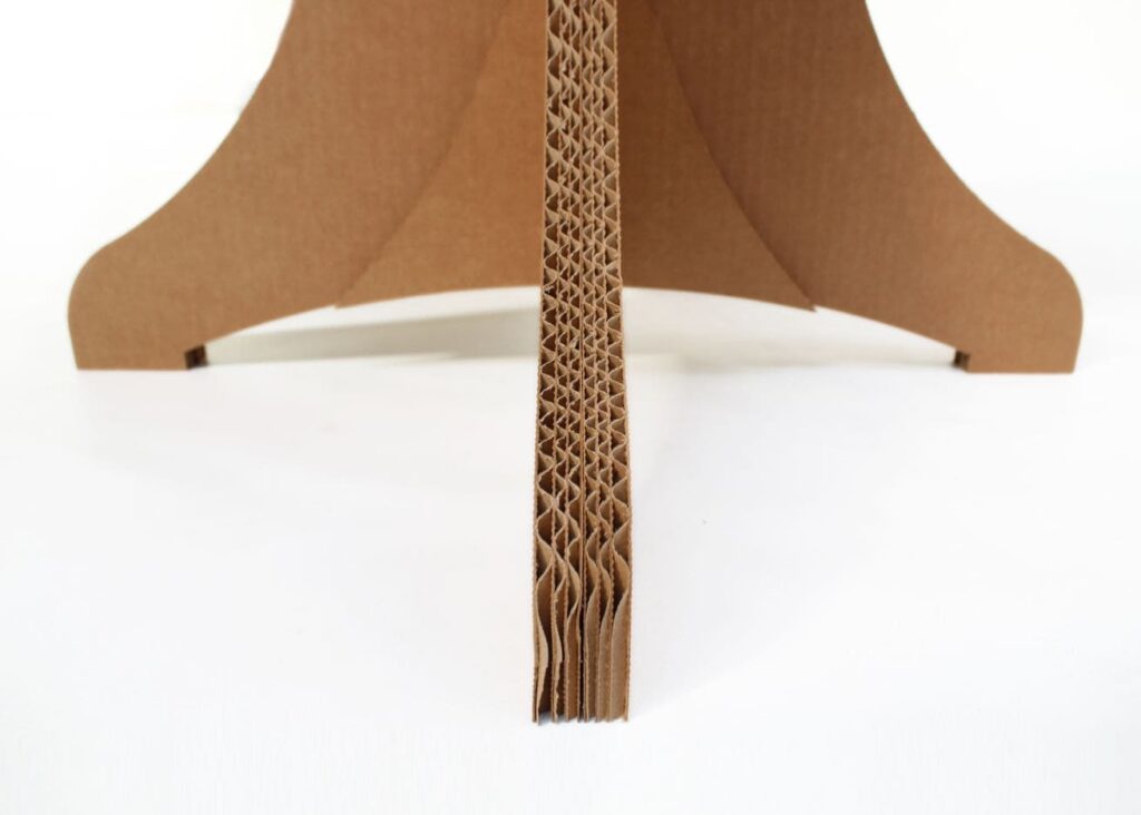 Guéridon en carton écologique à structure sculpturale pour espaces professionnels et événements, idéal pour salles de pause, stands événementiels ou décoration scénographique avec pieds en carton ondulé et plateau design en forme d'éventail - Le Meuble en Carton une marque du groupe Natur Design