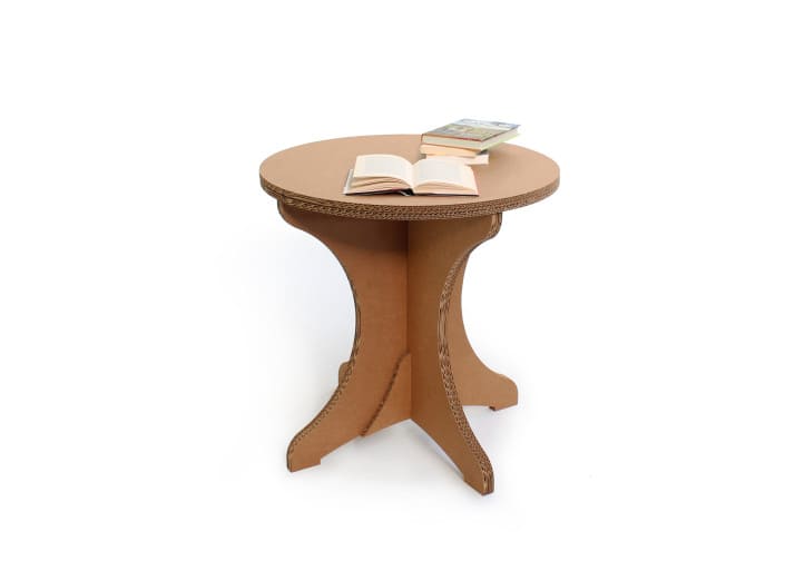 Guéridon cartonné TEBOULO en aménagement d'entreprise et salles de pause, plateau rond décoré pour accueil visuel dans les espaces professionnels ou événements scénographiques avec livres et documents posés sur son surface - Le Meuble en Carton une marque du groupe Natur Design
